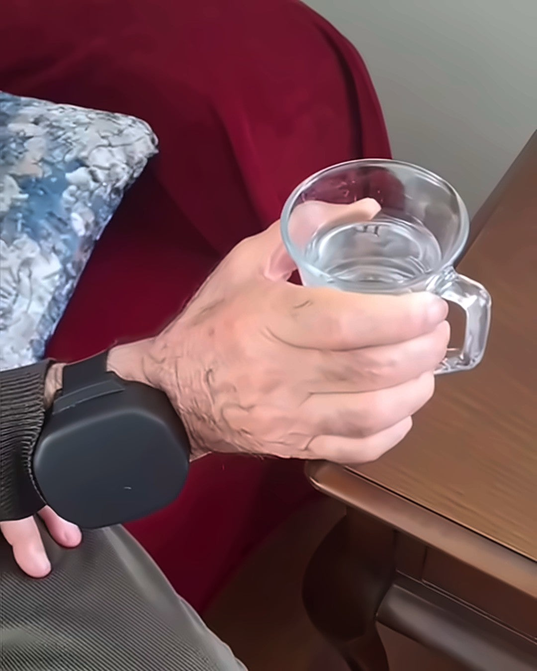 Anwender hält ein Glas Wasser mit Tremove am Handgelenk